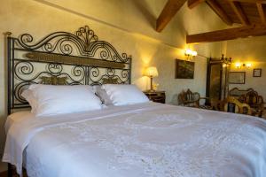 una camera da letto con un grande letto bianco con cuscini bianchi di Villa del Gattopardo a Palermo