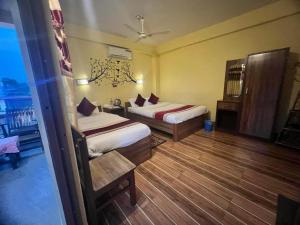 سرير أو أسرّة في غرفة في Hotel Mirage Sauraha