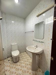 a bathroom with a toilet and a sink and a mirror at Seven-in in Ban Khlong Chi Lat