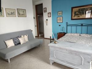 ソイアーノ・デル・ラーゴにあるB&B La Casarellaのベッドルーム(ベッド1台、ソファ付)