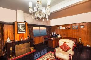 a living room with a chandelier and a chair and a desk at Central Gleneagles Heritage Resort Former Bungalow of Ex-TATA Chairman Russi Mody The Mall Road Darjeeling in Darjeeling