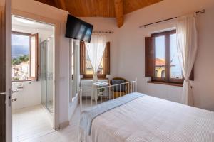 錫羅洛的住宿－Sirolo Sea rooms，卧室配有一张床,墙上配有电视。