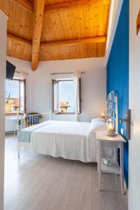 錫羅洛的住宿－Sirolo Sea rooms，一间卧室设有一张大床和蓝色的墙壁