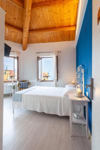 a bedroom with a large bed and a blue wall at Sirolo Sea rooms in Sirolo +40 photos