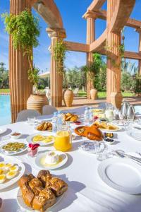 une table avec de la nourriture sur un tissu de table blanc dans l'établissement Villa marrakech, à Marrakech