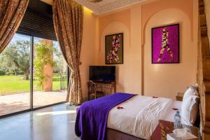 - une chambre avec un lit, un bureau et une fenêtre dans l'établissement Villa marrakech, à Marrakech