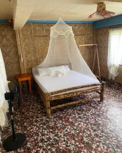 a bedroom with a bed with a net on it at Borbon's Treehouse By the Sea in Mambajao