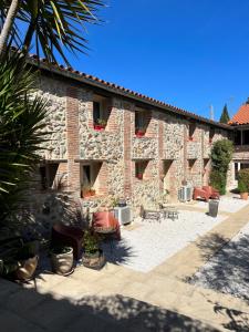 un grand bâtiment en pierre avec une cour ornée de plantes dans l'établissement Domaine De La Tannerie chambres d'hôtes et appartements, à Prades