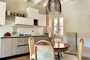 een keuken met een tafel en stoelen bij Borgo dei Sogni - Deluxe Apartment - Lago di Garda in San Felice del Benaco