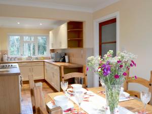 a kitchen with a table with a vase of flowers on it at West View in Sturminster Marshall