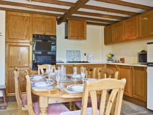 a kitchen with a wooden table with chairs and a dining room at Swallows Loft in Cromford