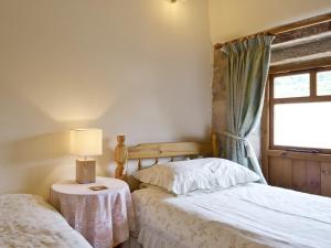 a bedroom with two beds and a window at Swallows Loft in Cromford