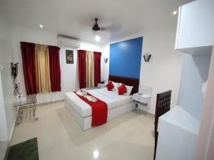 um quarto de hotel com uma cama e cortinas vermelhas em Hydel Palace Hotel & Resorts By Bestinn Leisure Athirappally em Athirappilly