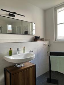 ein Bad mit einem Waschbecken und einem Spiegel in der Unterkunft M96 Ferienwohnung in Seßlach