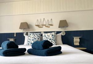 een bed met twee blauwe kussens erop bij Hôtel Bien-Être Aux Cyprès de Marquay in Marquay