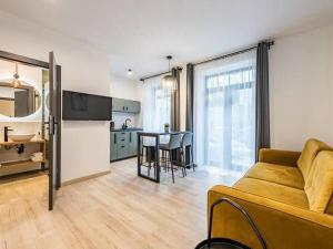 ザコパネにあるFerrata Apartamenty Zakopaneのリビングルーム(ソファ付)、キッチン(テーブル付)