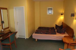a hotel room with a bed and a desk at Stadthotel Brandenburger Hof in Neuruppin
