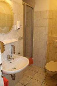 a bathroom with a sink and a toilet at Stadthotel Brandenburger Hof in Neuruppin