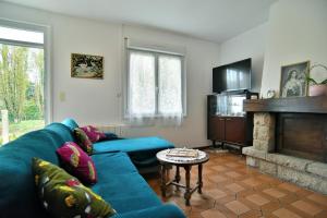 a living room with a blue couch and a fireplace at La Maison aux Volets Roses in Saint-Alban