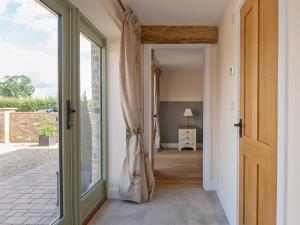 a hallway with a door leading to a bedroom at Eastlands Barn in East Barkwith