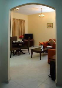 a living room with a table and a couch at New Royal Palace Hotel Apartments in Ajman 