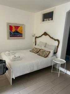 Cosy Home Napoli في نابولي: غرفة نوم بسرير ابيض وطاولة