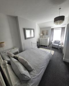 a bedroom with a bed and a chair and a window at Willesden, Flat 2, A 1 Bedroom flat right in the heart of Llandudno in Llandudno