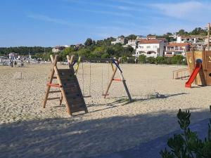 un parque infantil en la playa con columpios en Sandra -Lopar en Lopar