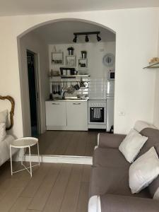 Cosy Home Napoli في نابولي: غرفة معيشة مع أريكة ومطبخ