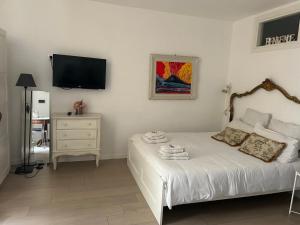 Cosy Home Napoli في نابولي: غرفة نوم مع سرير وتلفزيون على الحائط