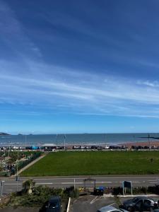 a view of the beach and the ocean from a parking lot at The Commodore Rooms & Relaxation in Paignton