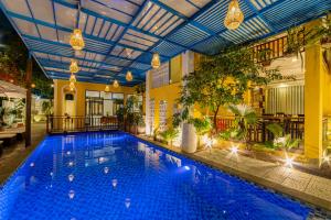 una grande piscina in un edificio con soffitto di Hoi An Heart hostel Villa a Hoi An