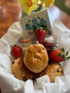 a basket of muffins and strawberries on a table at The Commodore Rooms & Relaxation in Paignton