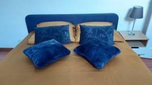 a blue bed with blue pillows on it at L'Appel de la Loire in Saumur