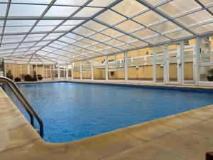 une grande piscine intérieure avec un toit dans l'établissement Apartamentos Terraza playa 3, à Foz