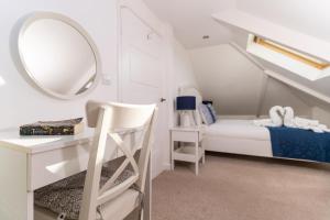 una camera con letto, scrivania e specchio di Stunning Views Over Mounts Bay with Balcony a Penzance