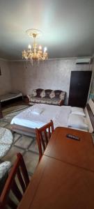 a bedroom with a bed and a table and a chandelier at Camelot hotel in Bishkek