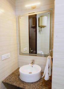 a bathroom with a white sink and a mirror at Plaza Residency in Gurgaon