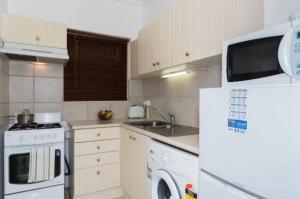 a kitchen with a white refrigerator and a microwave at M104 West Perth Studio Apartment near Kings Park in Perth