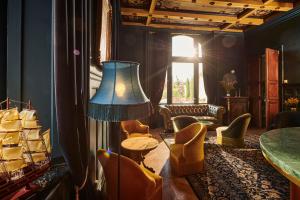 a living room with a table and chairs and a lamp at Boutique Hôtel Château Beaupin Restaurant & Wellness in Marseille