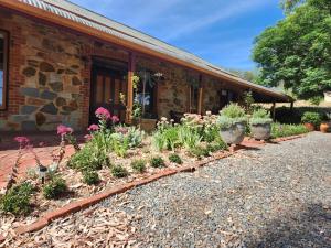 a garden in front of a building with flowers at Marananga Cottages in Marananga