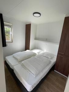 a bedroom with a large bed with white sheets at Zee en duin in IJmuiden