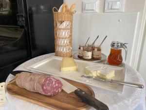 uma tábua de corte com carne e queijo sobre uma mesa em Principessa di Savoia em Vicoforte
