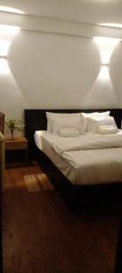 um quarto com uma cama com lençóis brancos e almofadas em Heart of the Hill em Nuwara Eliya