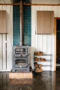 a stove in a kitchen with some loaves of bread at Strawbale Cottage - Wingspread Garden in Strath Creek