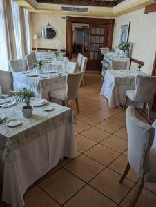 una sala da pranzo con tavoli e sedie con tovaglie bianche di Hotel Salvador a Bailén