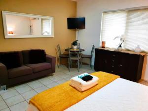 a room with a bed and a couch and a table at M104 West Perth Studio Apartment near Kings Park in Perth