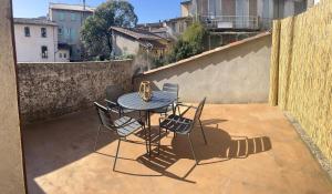 een patio met een tafel en stoelen op een balkon bij Triplex en Cévennes in Saint-Jean-du-Gard