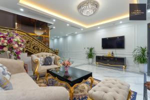 a living room filled with furniture and a tv at Luxury Homestay Vinhomes Dragonbay Hạ Long in Ha Long
