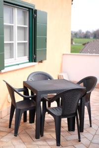 una mesa negra y sillas en un patio en B&B Belvedere, en Lurago Marinone